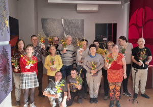 Zdjęcie grupowe. Osoby stoją, w rękach każdy trzyma wykonaną przez siebie palmę wielkanocną.