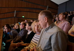 Grupa osób siedząca na widowni.