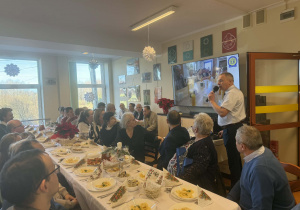 Grupa osób siedząca przy świątecznym stole.