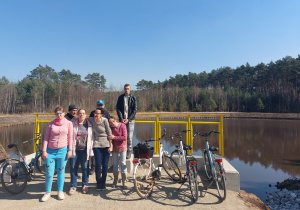 Grupa kobiet i mężczyzn obok rowery w tle jezioro
