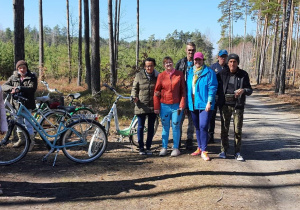 Grupa kobiet i mężczyzn obok rowery w tle las