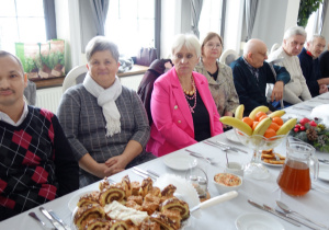 Grupa kobiet i mężczyzn siedzących przyprzy stole