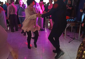 Kobieta i mężczyzna w masce tańczą w parze