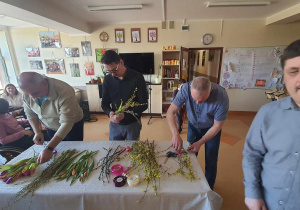 Grupa mężczyzn robiących bukiety z kwiatów