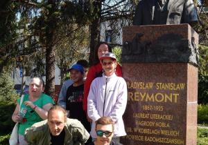 Grupa osób przy pomniki Władysława Reymonta.